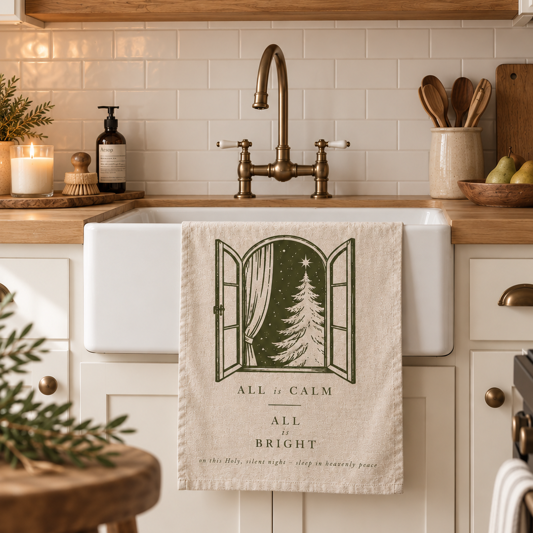 Tea Towel hanging over kitchen sink with words 'all is calm, all is bright'.