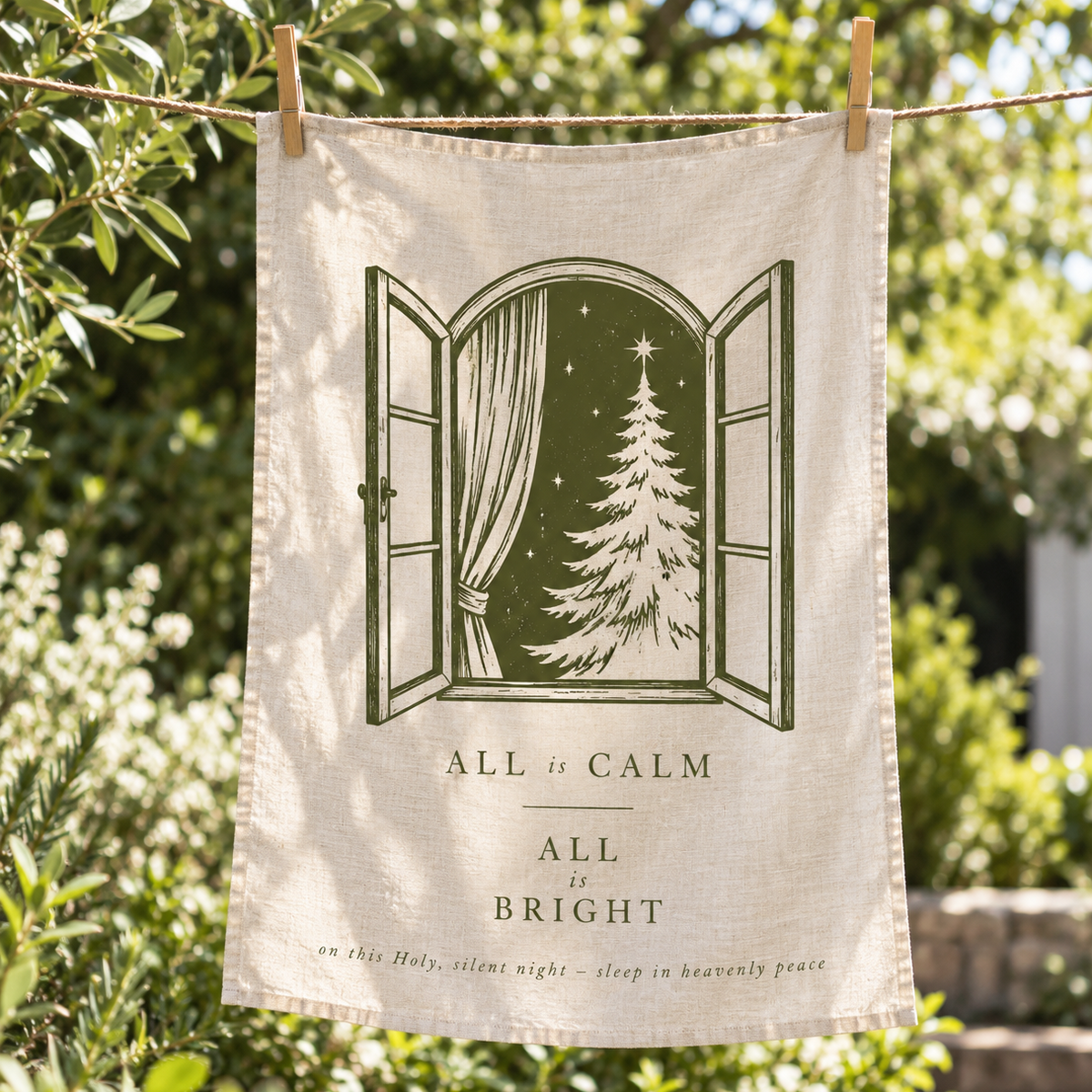 Tea towel hanging on line with words 'all is calm, all is bright' .