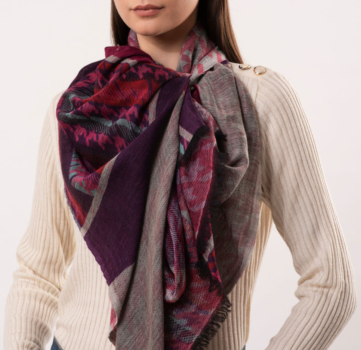 Person wearing a patterned scarf with a neutral background