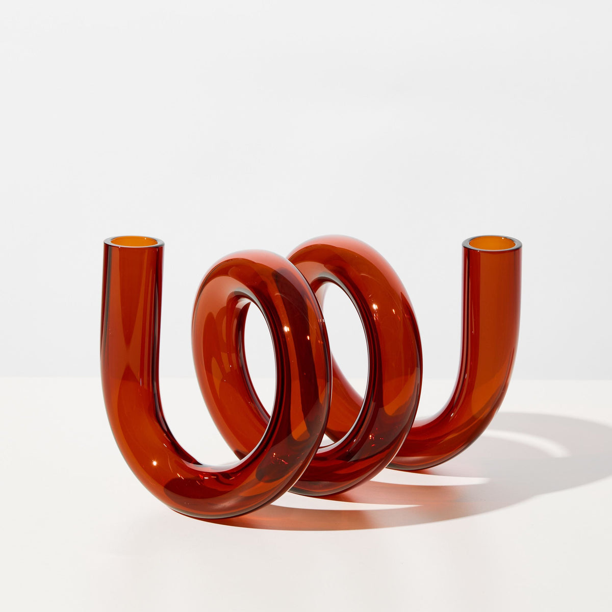 Sculptural amber-colored object/vase on a white background