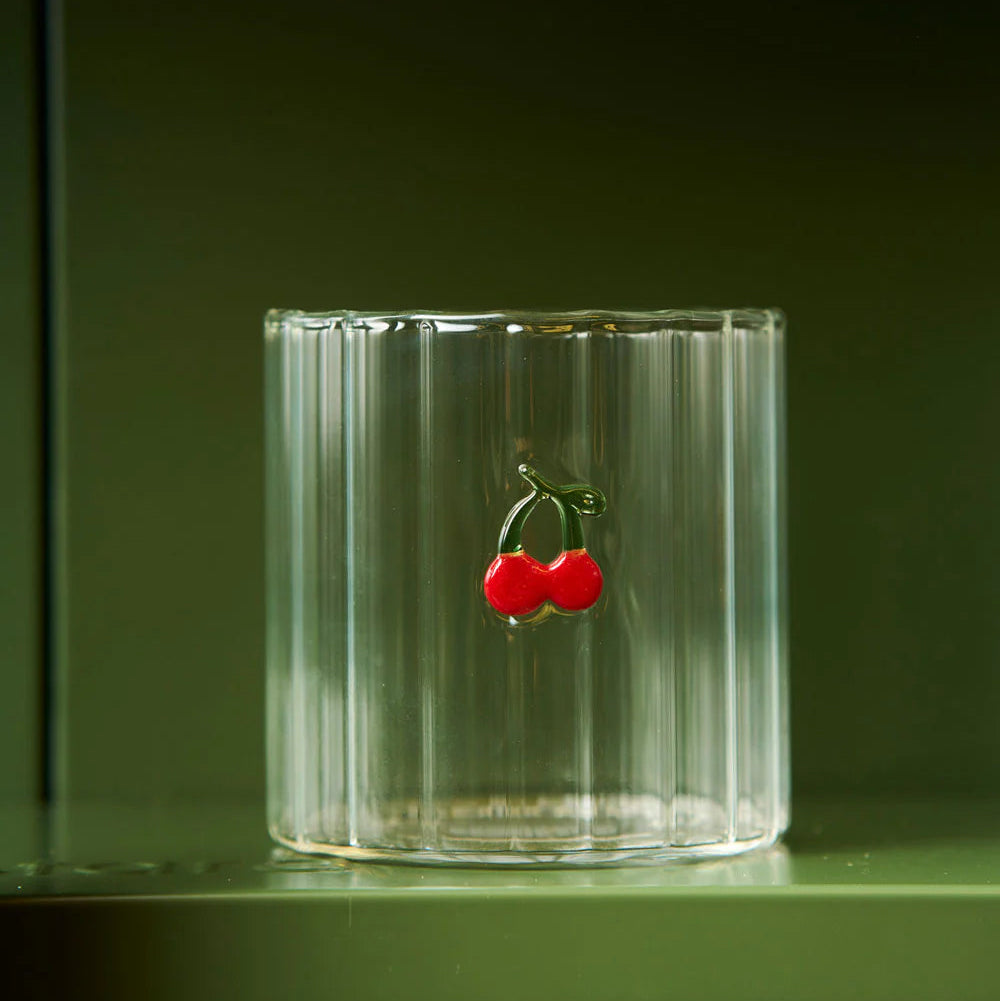 Clear glass with a cherry design on a dark green background