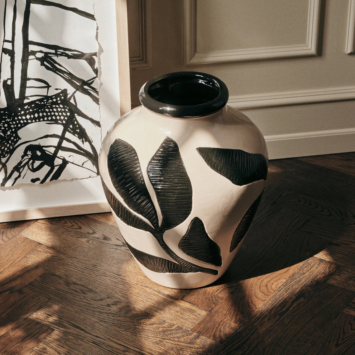 A black and white patterned ceramic vase on a wooden table
