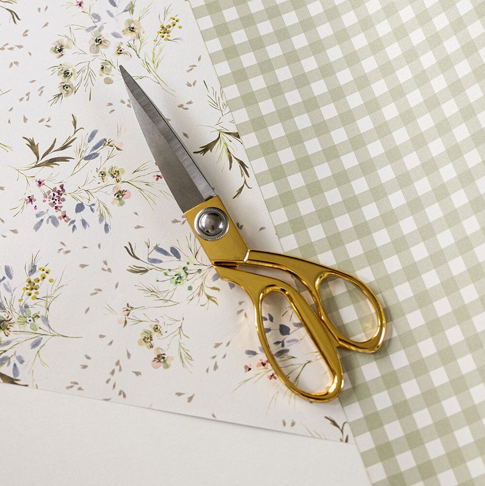 Gold handled crafting scissors on floral fabric