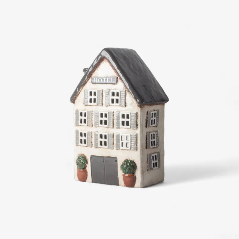 Decorative house-shaped container with a black roof on a white background
