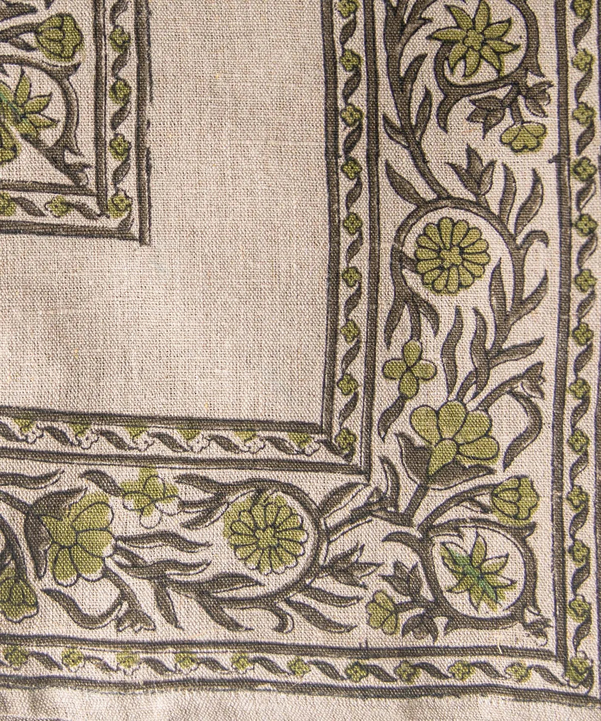 Close-up of a fabric with green floral patterns on a beige background