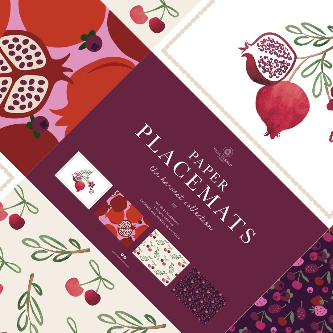 Collection of paper placemats with fruit and floral patterns on a purple background.