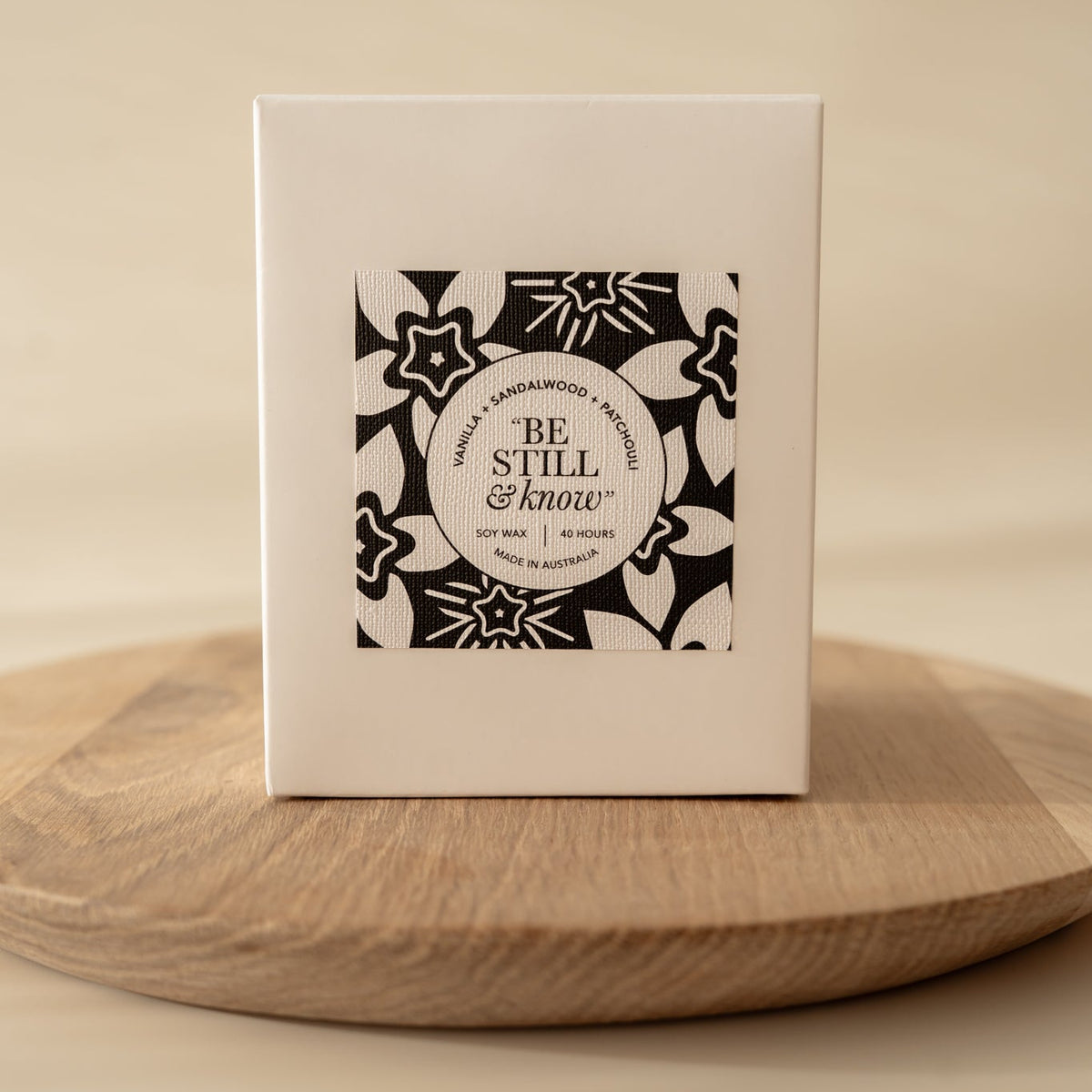 Well Versed Homes Signature Candle in box sitting on wooden board