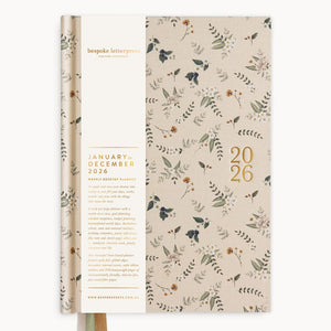 Floral-patterned diary with gold text on a white background