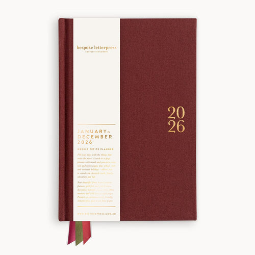 Maroon planner with gold text on a white background