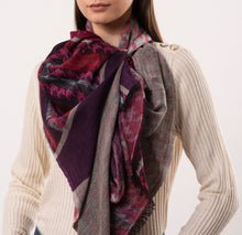 Person wearing a patterned scarf with a neutral background