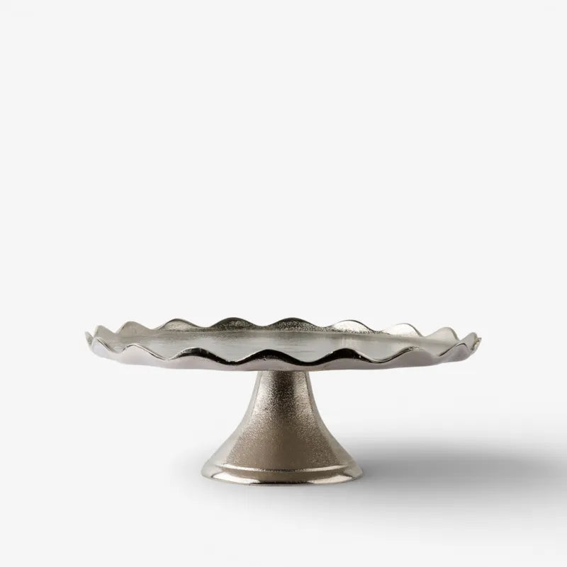 Decorative cake stand with wavy rim on a white background