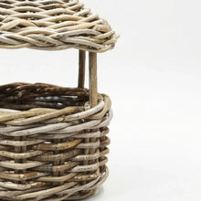 Close-up of a woven wicker basket with a rounded top and vertical support posts, shown on a clean white background.