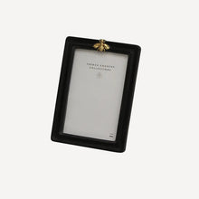 Black photo frame with a gold bee design on a white background