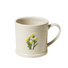 White mug with yellow floral design on a white background