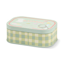 A rectangular metal tin candle with a pastel green and cream gingham patterned body and a mint green lid. The lid features a decorative label with the word 'MACARON' in pink and illustrations of a macaron and a whisk.