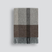 Plaid blanket with gray and brown check pattern on a light gray background