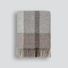 Gray checkered blanket with fringed edge on a light gray background