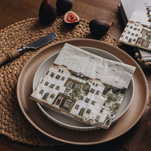 Table setting with a patterned napkin, figs, and a knife on a wooden table.