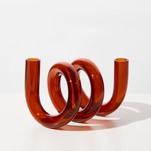 Sculptural amber-colored object/vase on a white background