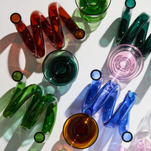 Colorful glassware including bottles and glasses on a white surface