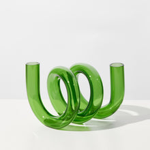 Green glass curly vase on white background
