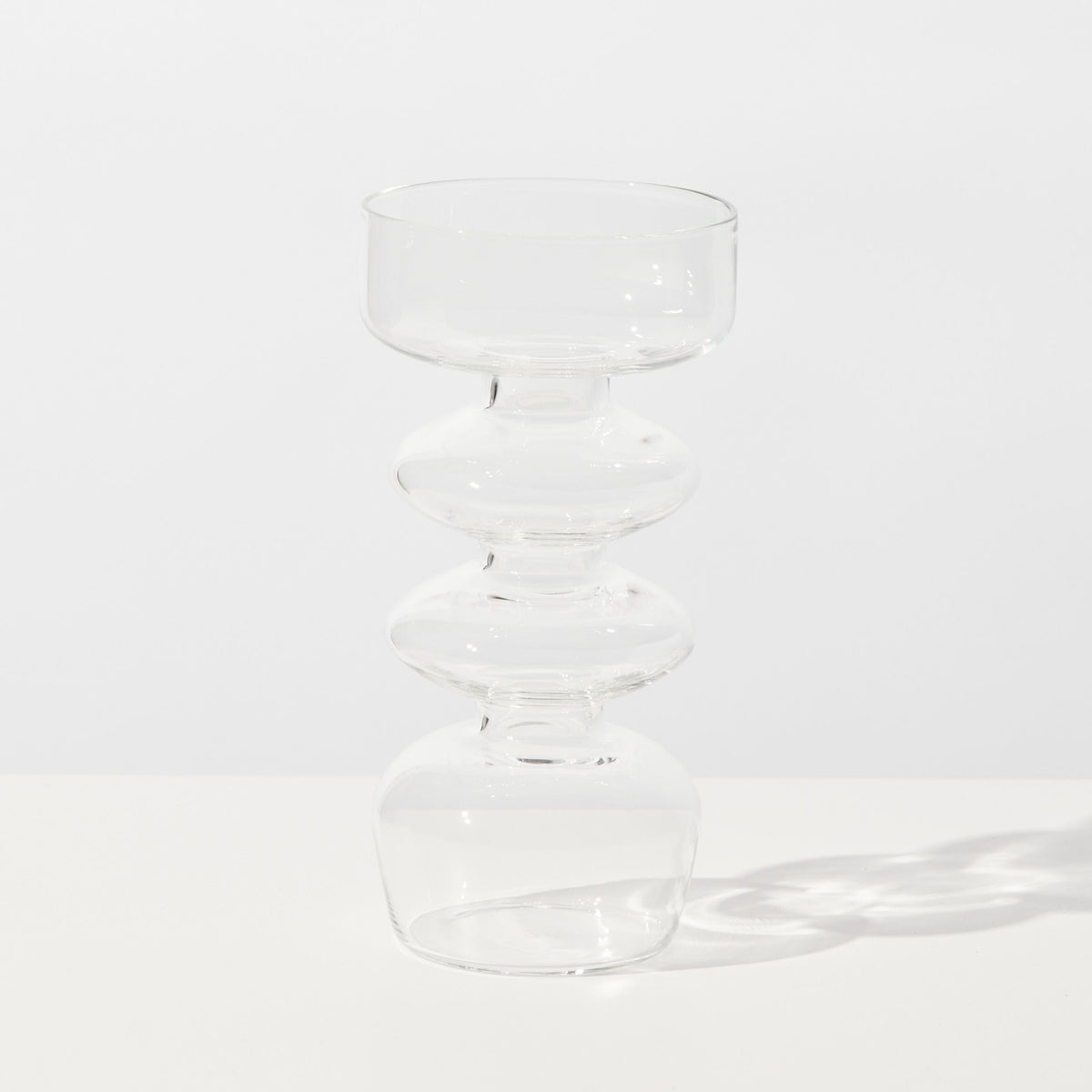 Clear glass vase with wavy design on a white background