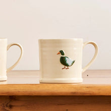 Two ceramic mugs on a wooden shelf with a plain background