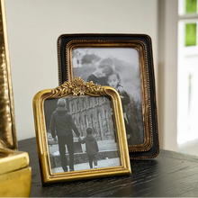 Two vintage-style picture frames on a surface with a blurred background
