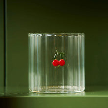 Clear glass with a cherry design on a dark green background