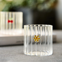 Clear glass with a gold flower design on a blurred background