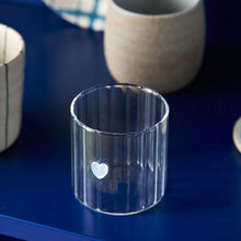 Clear glass with a heart on blue background