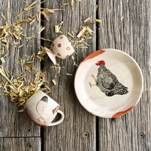 Ceramic items with chicken design on a wooden surface