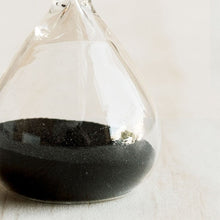 Hourglass with black sand on a white background