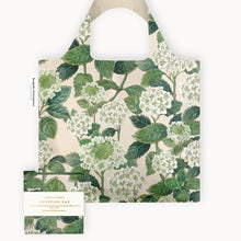 Floral patterned apron with matching shopping bag on a white background