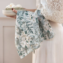 Person holding a floral-patterned towel with a neutral background