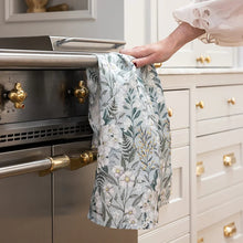 Person using a floral towel to open a kitchen oven door.