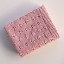 Pink knitted baby blanket on white background