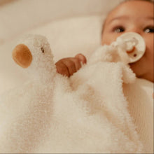 Baby holding a plush toy with a soft focus background