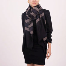 Person wearing a black outfit with a patterned scarf on a white background