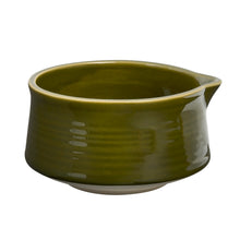 An olive green glazed ceramic matcha bowl with a small pouring spout, shown on a plain white background.