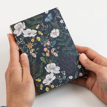 Floral notebook held by a person on a white background