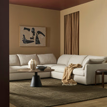 Modern living room with a sectional sofa, coffee table, and abstract art on the wall.