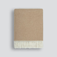 Beige blanket with white fringe on a light gray background