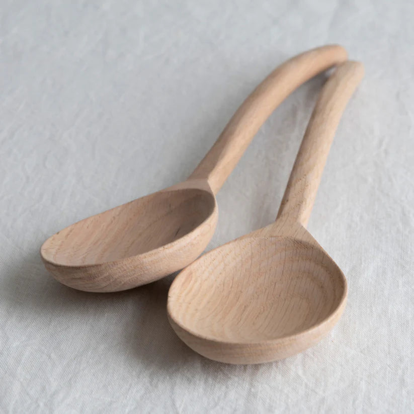 Two wooden spoons on a light gray background