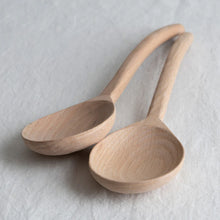 Two wooden spoons on a light gray background