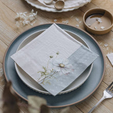 Table setting with floral napkin on a wooden table