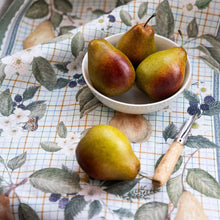 Pears in a bowl on a floral tablecloth