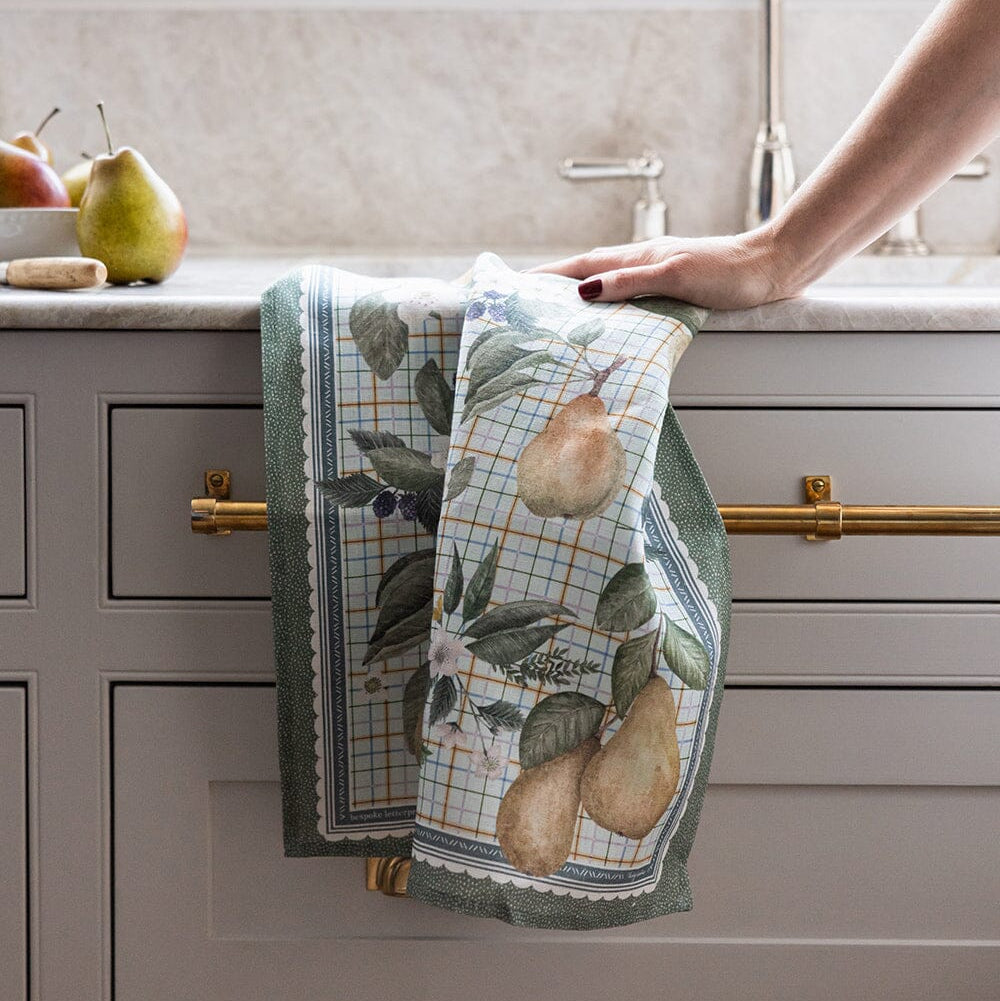 Kitchen towel with pear design hanging on a cabinet handle