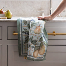 Kitchen towel with pear design hanging on a cabinet handle