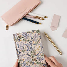 Floral-patterned planner with 2026 on a white surface with stationery items.